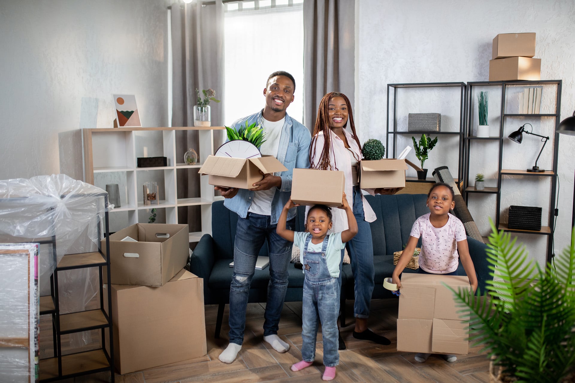 Cheerful,Afro,American,Family,Holding,Boxes,While,Standing,At,Bright
