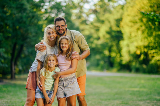 Portrait,Of,A,Happy,Young,Family,Standing,Together,In,Nature
