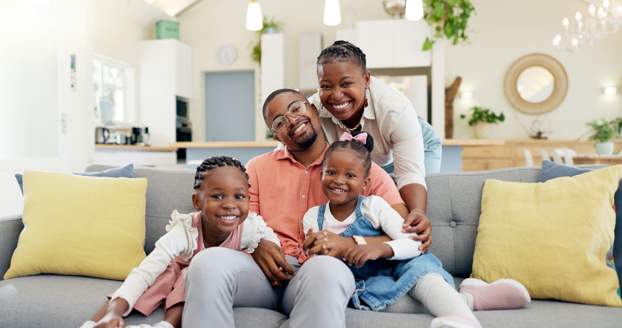 Happy, black family on sofa and in living room of their home happy together for care. Support or love, happiness or positivity and African people cuddle on couch in their house for bonding time (1)