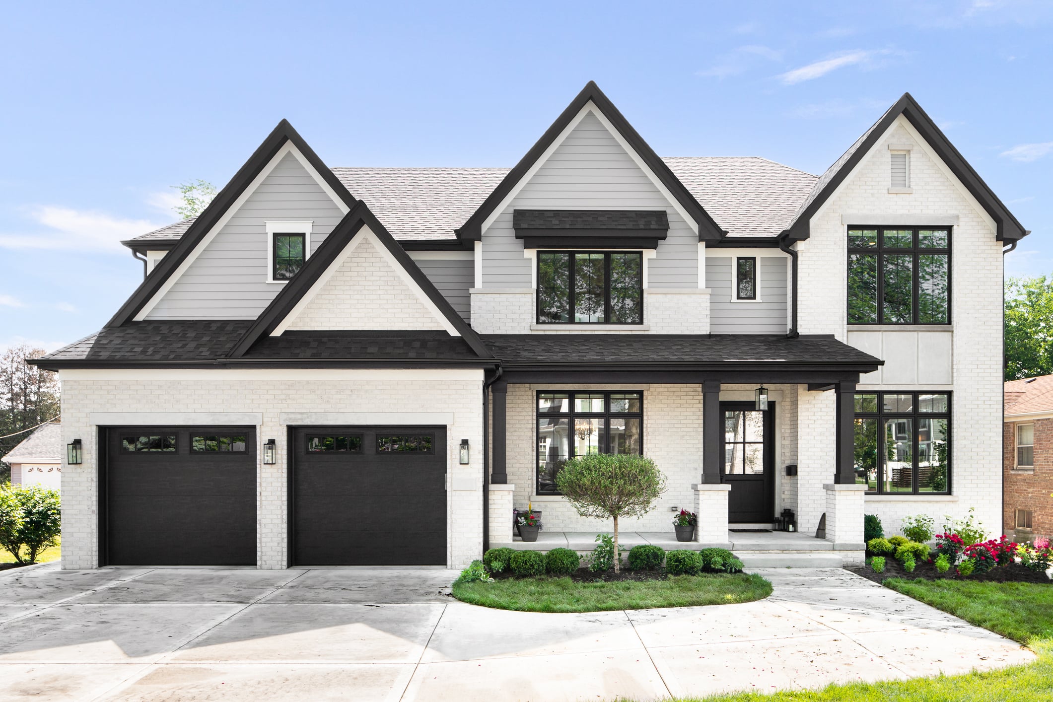 A grey and white modern farmhouse with black accents.