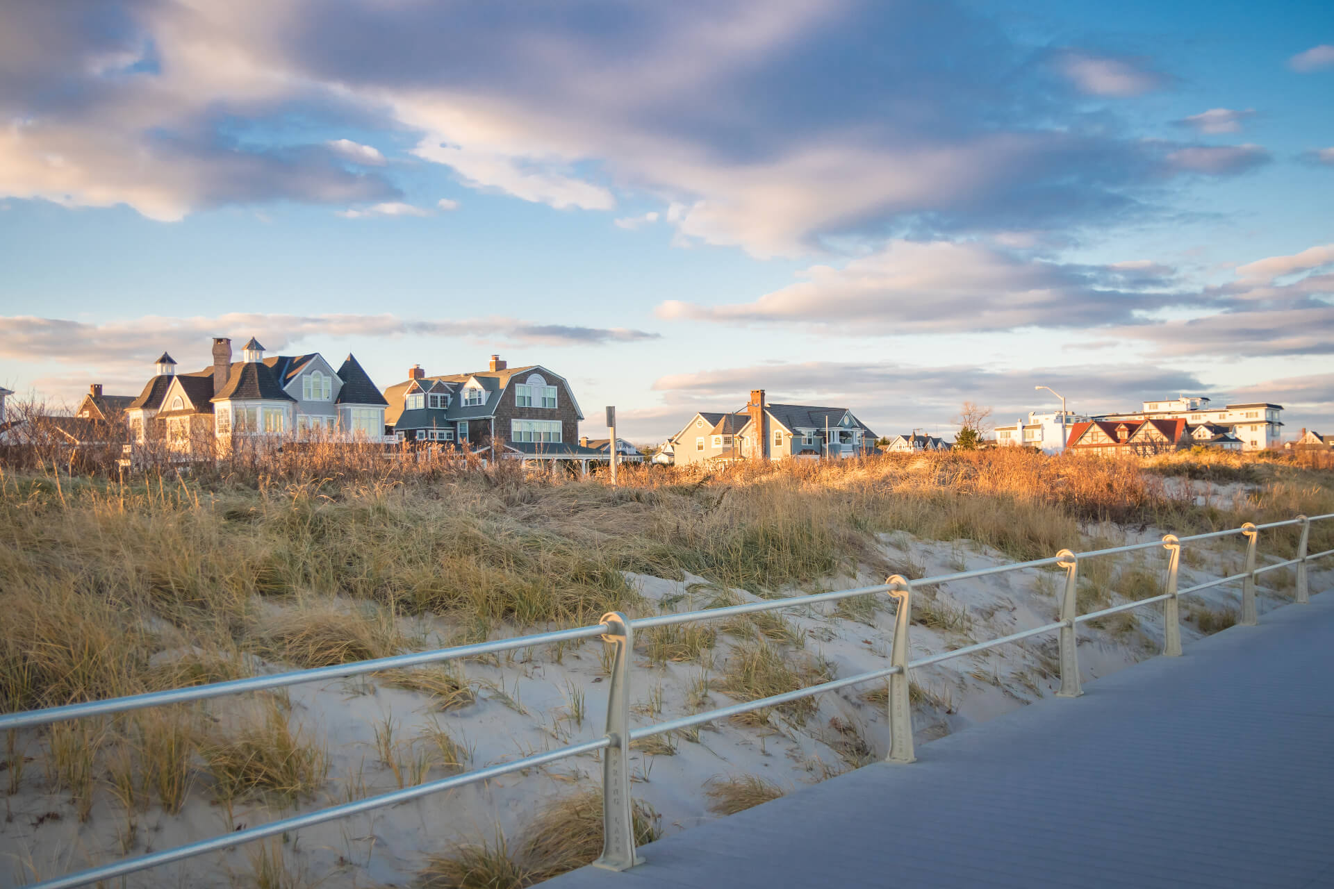 Luxury summer homes along the coastline and board walk in Spring Lake, New Jersey; against pastel colored sunset skies