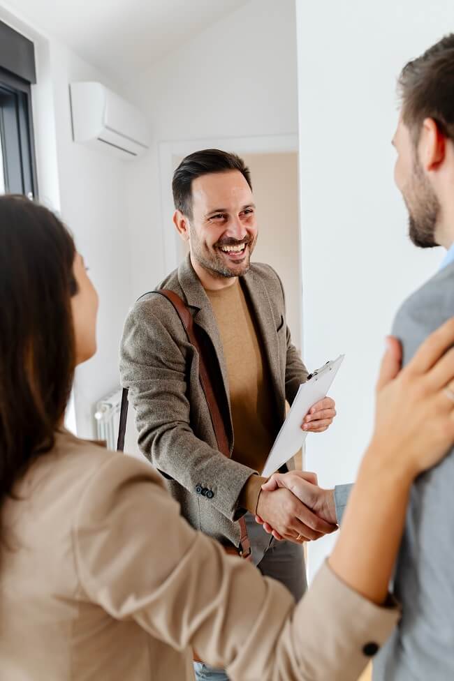 a couple talking with a real-estate agent visiting apartment for sale