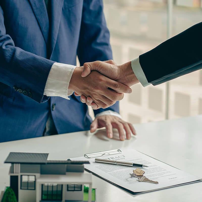 A real estate agent shakes hands with a client