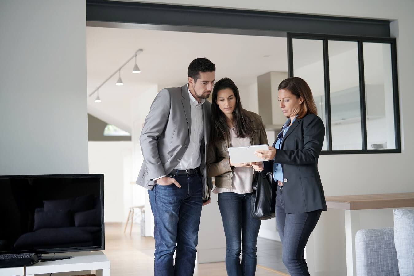 Couple with real-estate agent visiting modern house