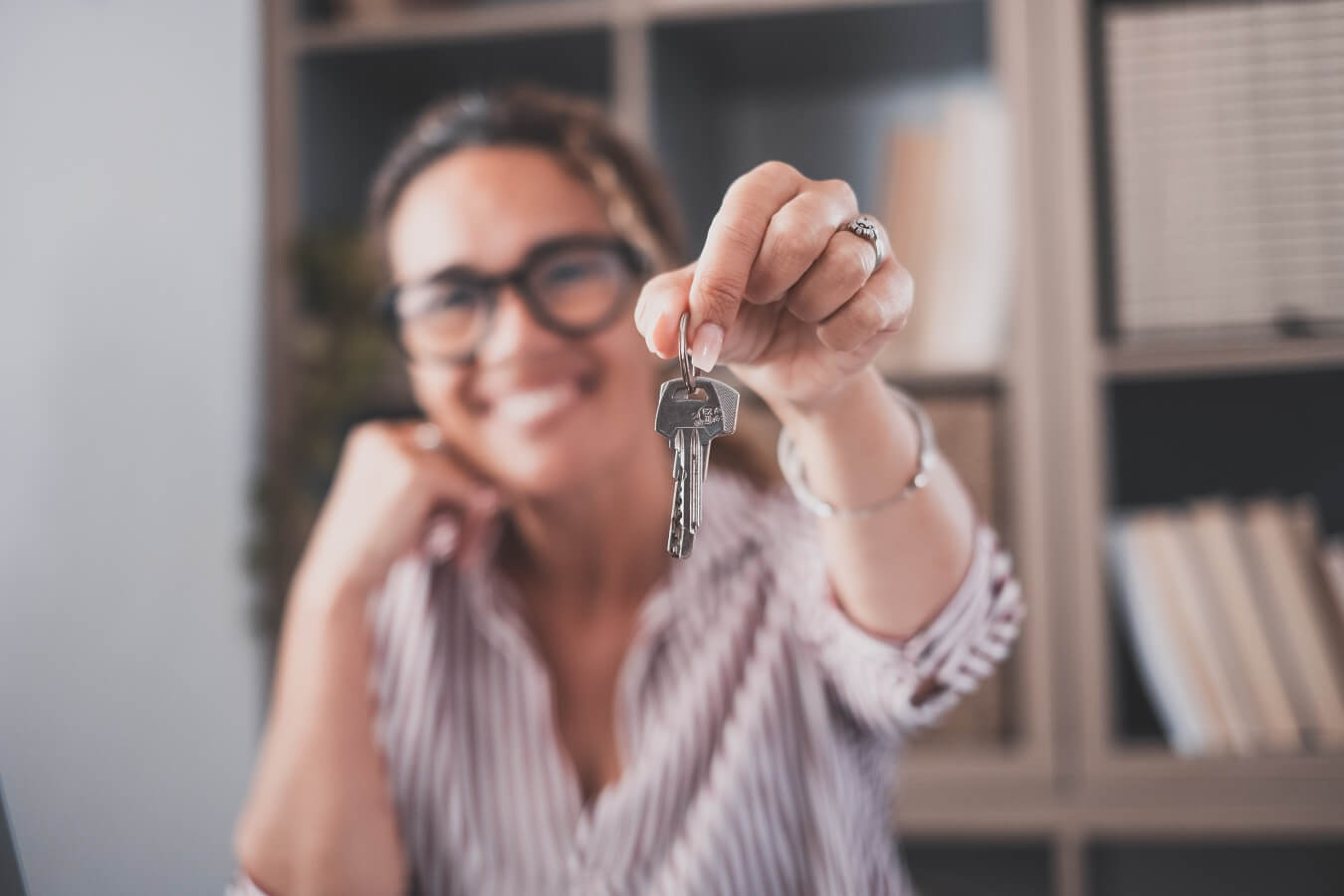 Focus on bunch of keys from house flat apartment in hand of smiling female