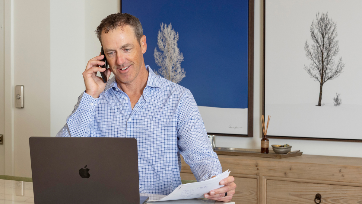 Steven Mullins reviewing documents while speaking with a client about buying a home in the South Bay.