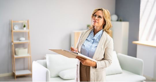 A woman wearing a coat and holding files in her hand.