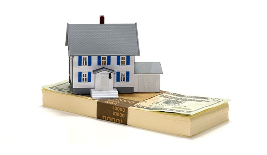 Model house on a stack of US $100 bills