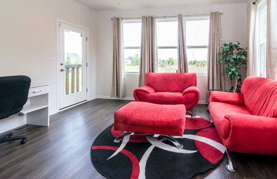 image depicts a modern living space or den, likely within a home, featuring seating area