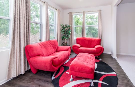 image depicts a modern living space or den, likely within a home, featuring seating area