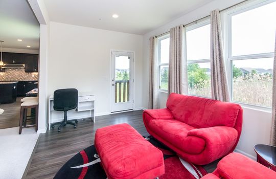 image depicts a modern living space or den, likely within a home, featuring seating area