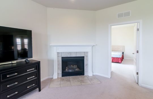 image displays a room with a central focus on a fireplace and a television setup
