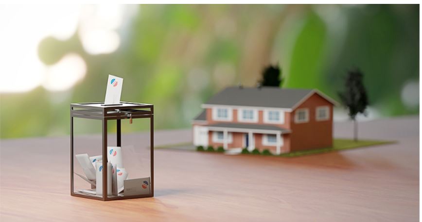 image depicts the concept of proxy voting in a Homeowners' Association (HOA), where a ballot box with proxy forms is shown alongside a model house