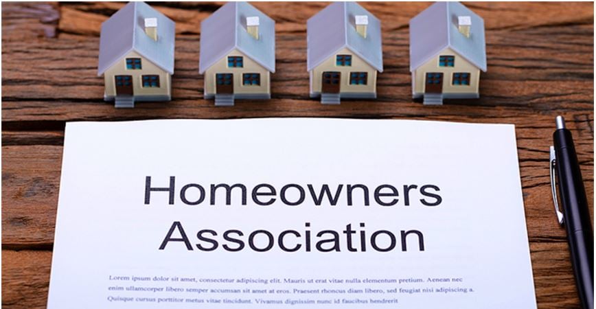 image prominently displays the title "Homeowners Association" on a document, surrounded by miniature house models, signifying its central theme