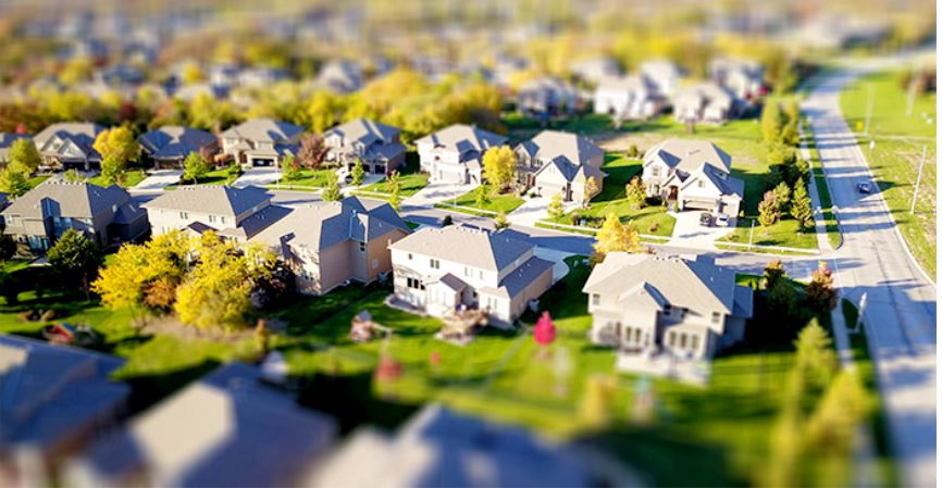 an aerial view of a suburban neighborhood with many houses, trees, and roads