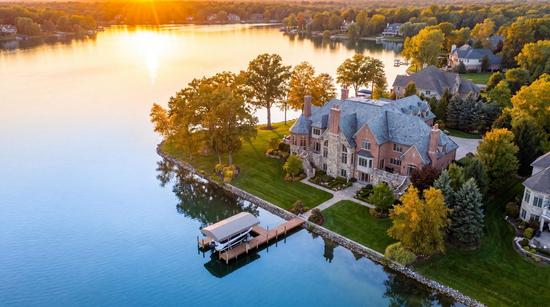 Luxury lakefront estate aerial view on a private Oakland County Michigan lake at golden hour — best realtor Farmington Hills Michigan — waterfront homes for sale Oakland County Michigan — Tom Gilliam RE/MAX Classic — 248-790-5594 — Homes2MoveYou.com