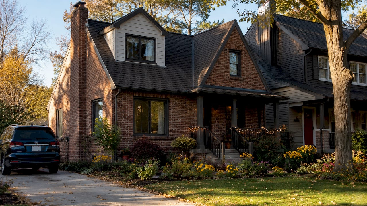 Brick rental home exterior with dormer windows and landscaped front yard in Farmington Hills, Michigan