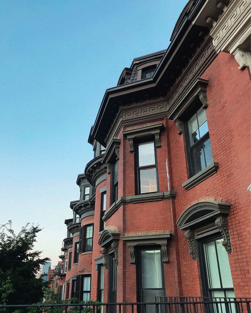 A row of brownstone townhomes in a Boston neighborhood