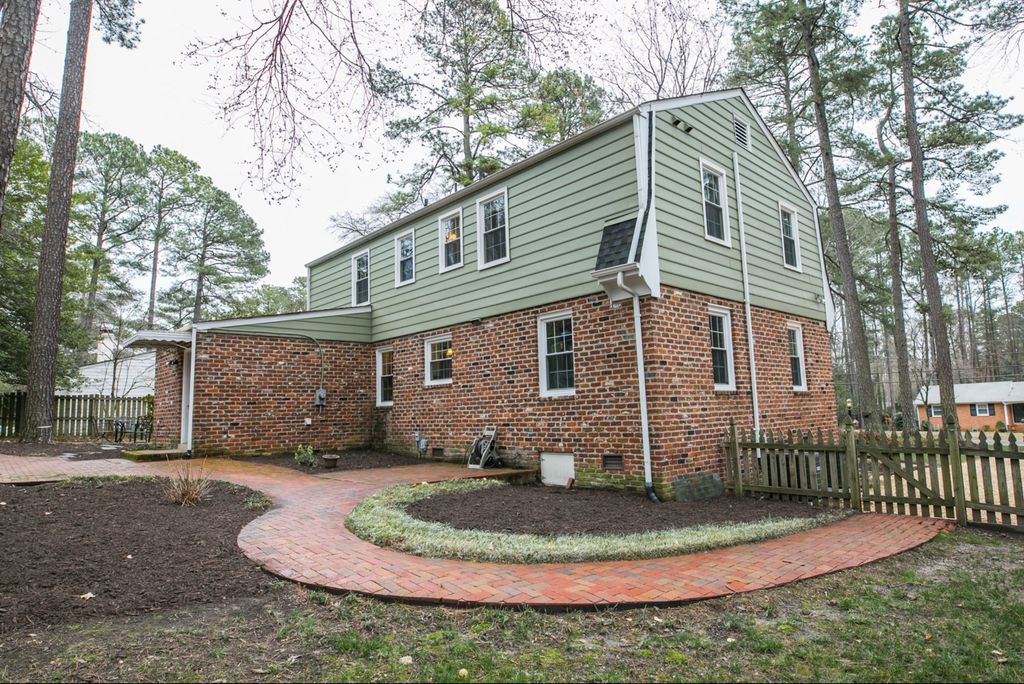 A mid-century brick and siding Dutch colonial under tall pines in Bon Air, Virginia