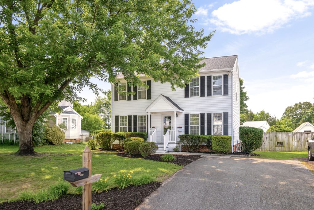 A white colonial with black shutters and a mature shade tree in Lees Crossing, Glen Allen, Virginia
