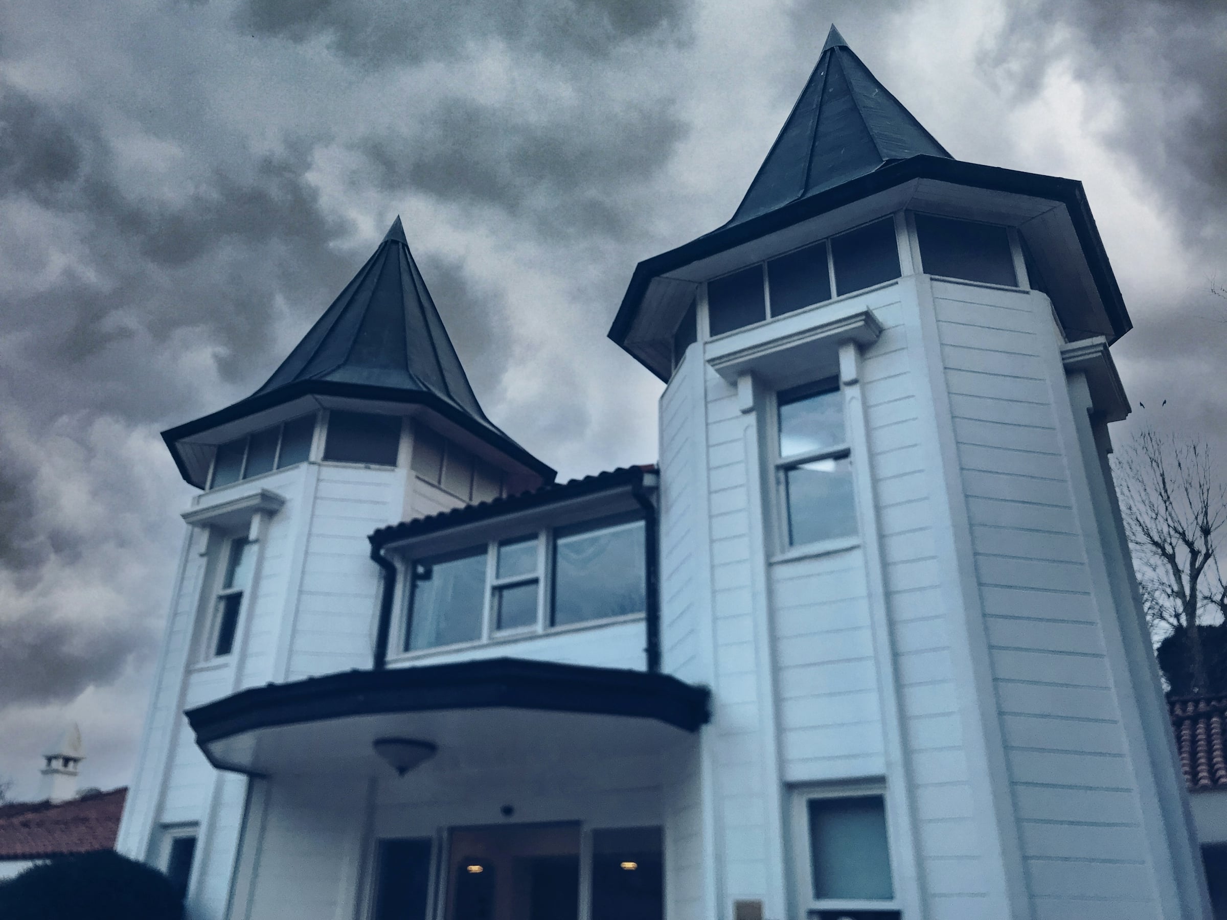 Large gray house with a peaked corner tower