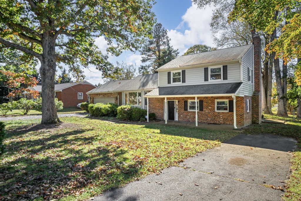 A brick two-story home with a large oak tree in the front yard in Mechanicsville, Virginia