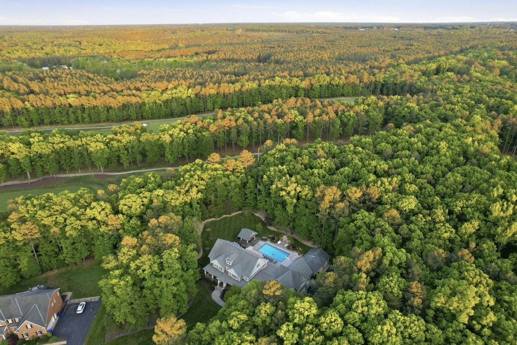 Aerial view of a Mountain Run home on a wooded lot with Federal Club golf fairways and Hanover County forest beyond