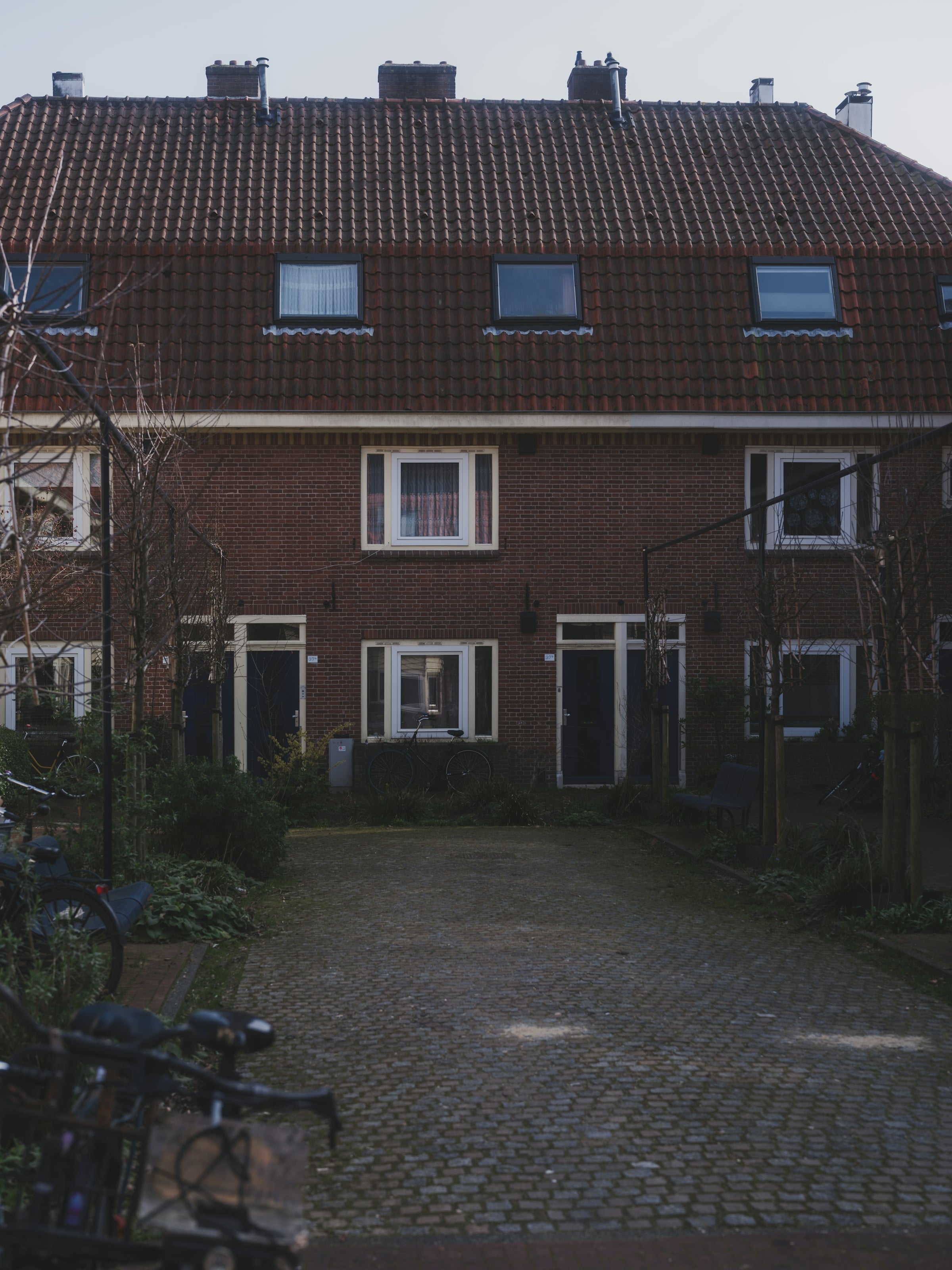 A row of attached brick townhouses with white-trimmed windows along a street