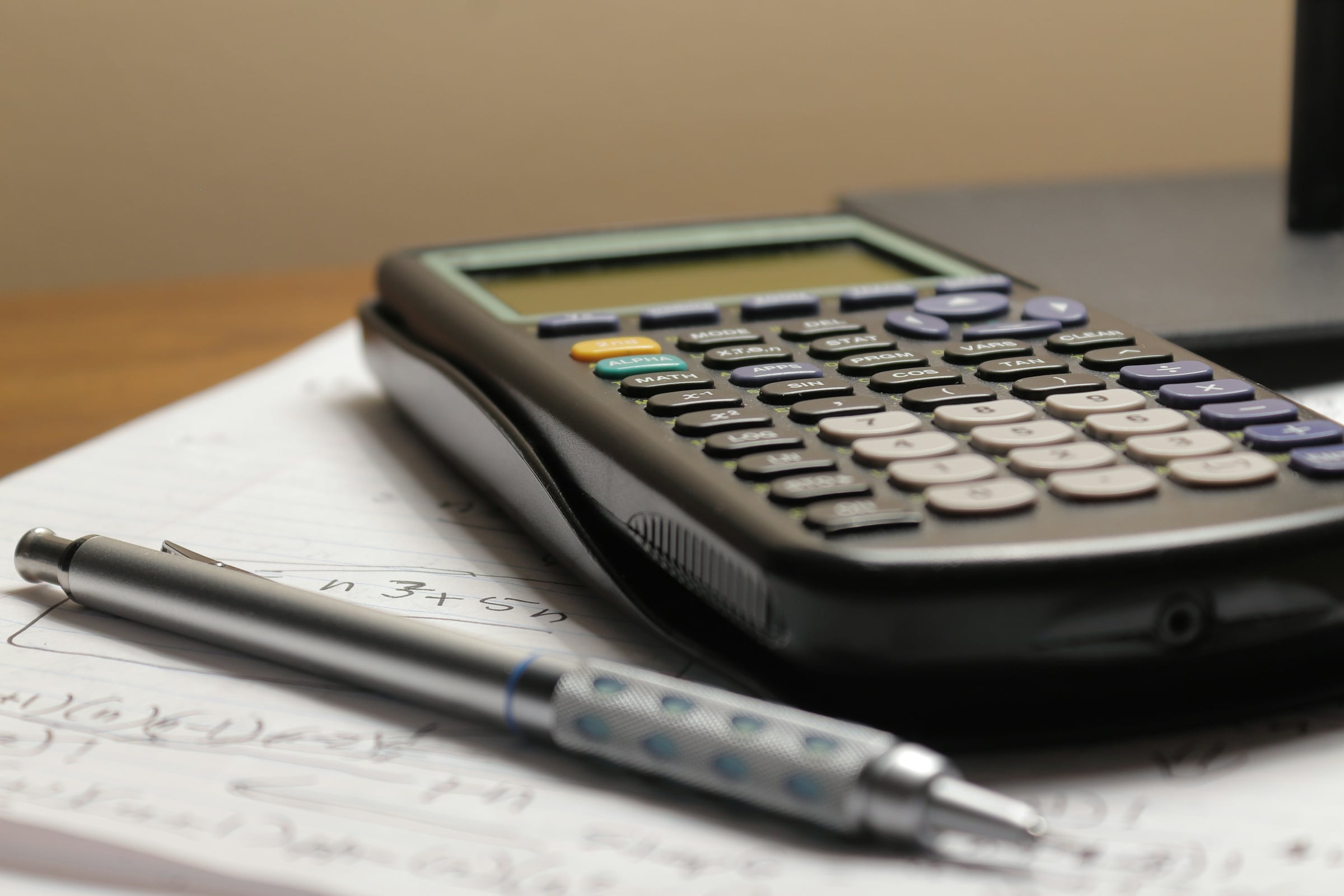 Calculator and pen on a desk with paperwork