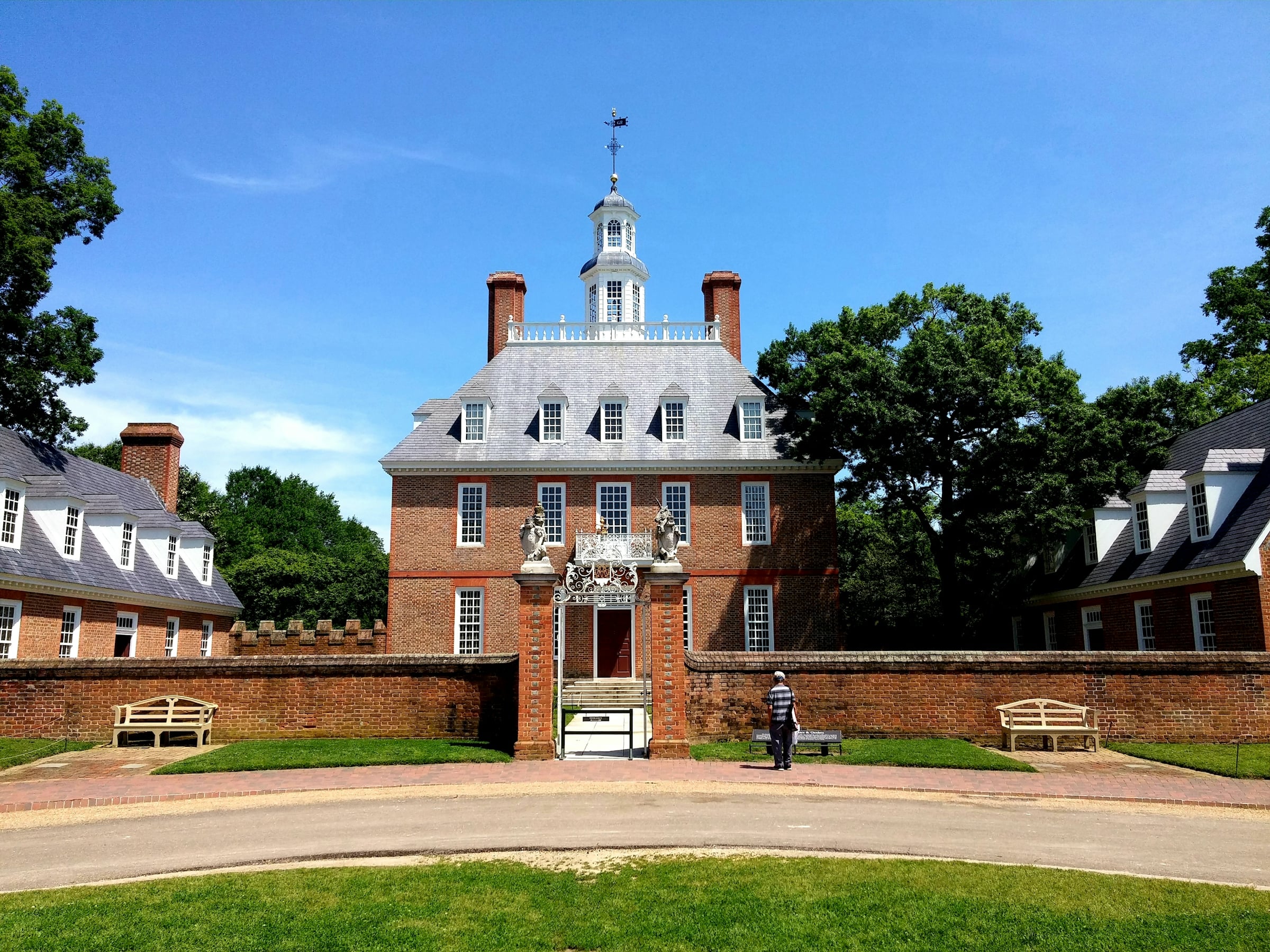 Georgian brick building with a white cupola and manicured lawn in Colonial Williamsburg