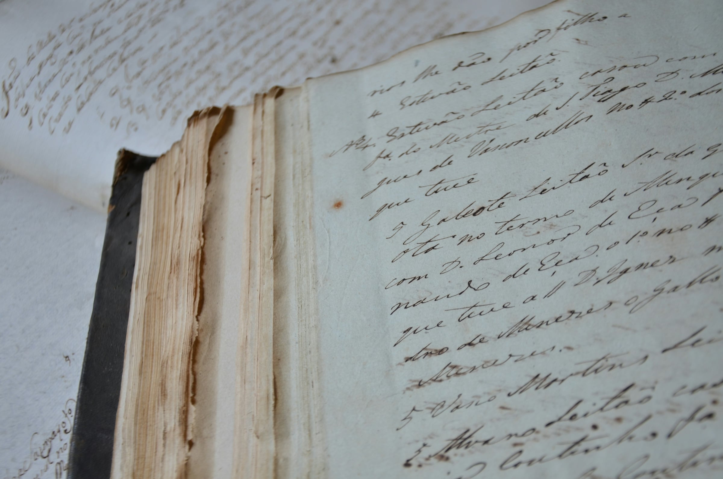 An open antique book showing pages of handwritten cursive entries in faded brown ink