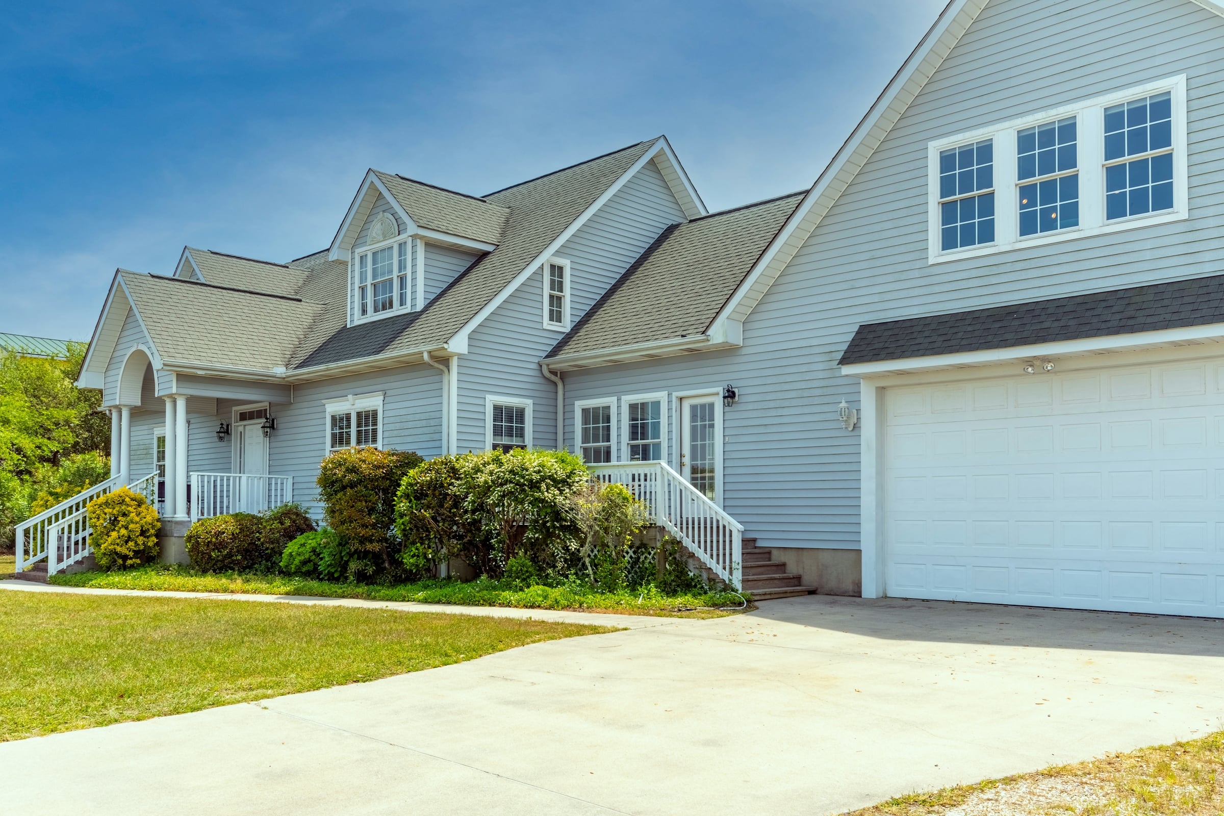 Light-colored house with an attached garage and lawn