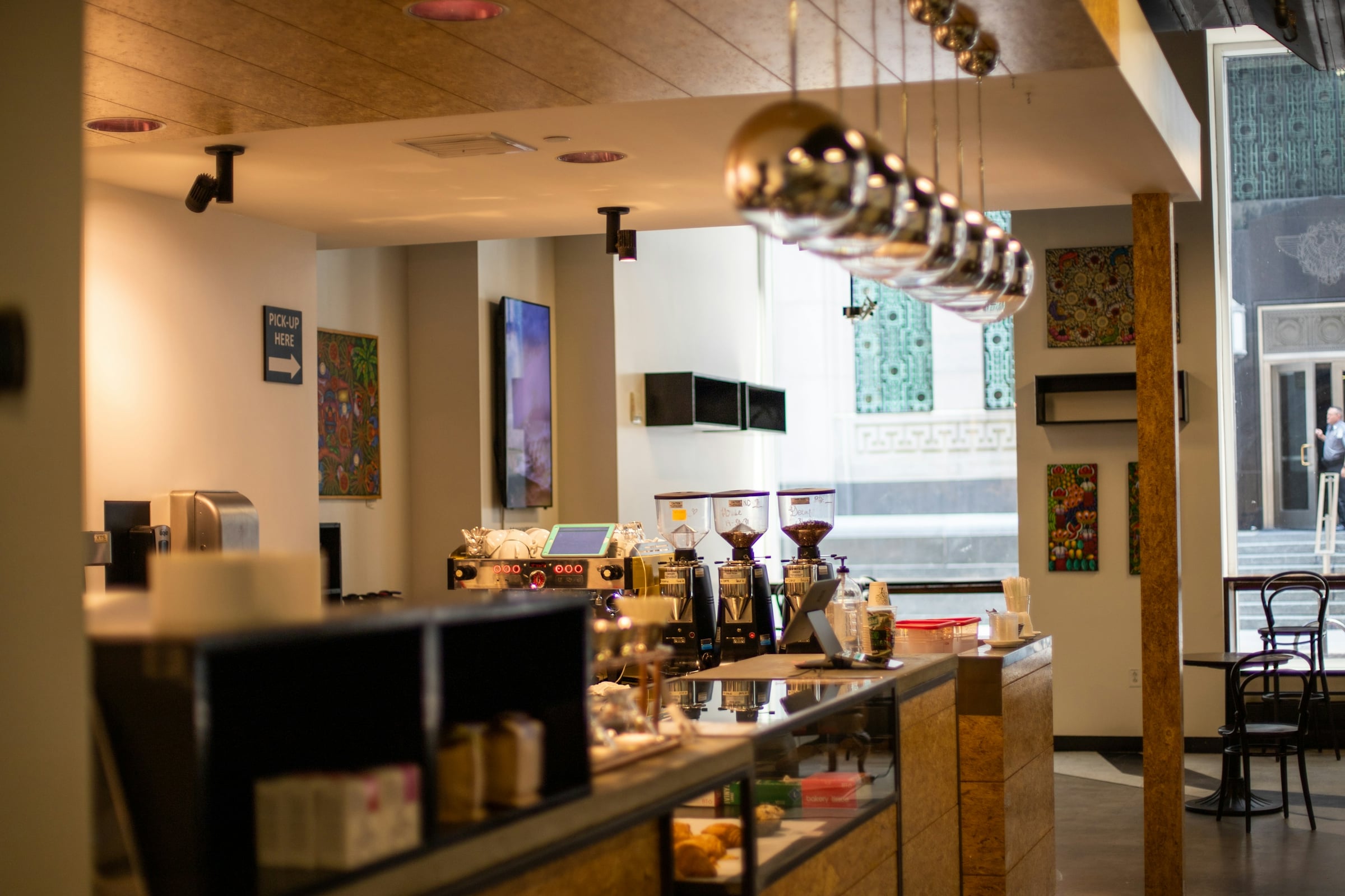 Bright cafe interior with a service counter, pendant lighting and cafe seating