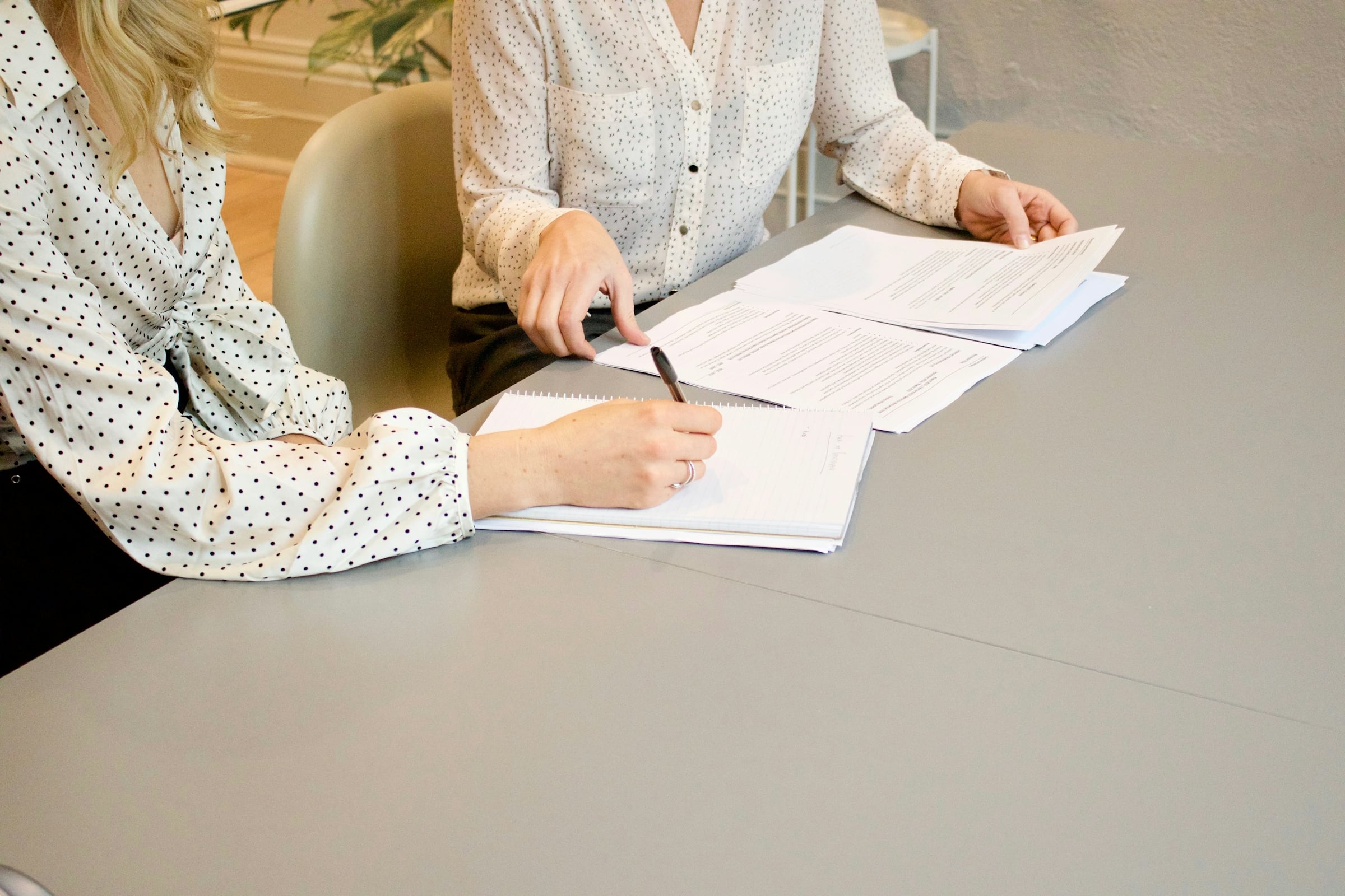 Two hands signing a printed document
