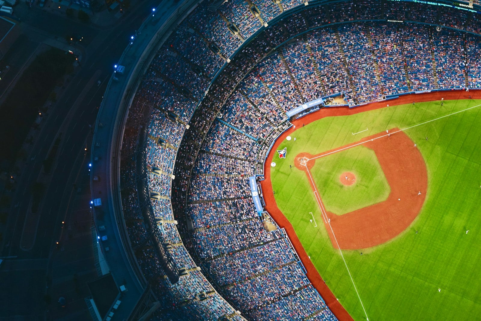 Aerial view of a baseball stadium with a green infield and crowded stands