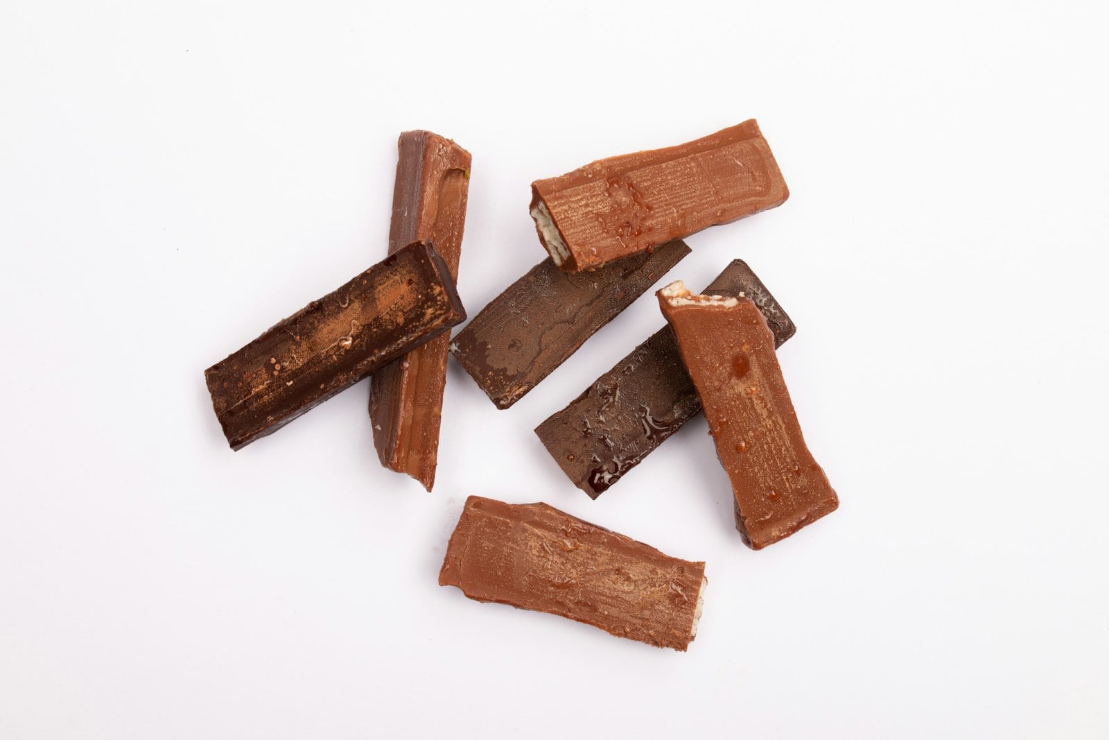 Pieces of chocolate candy bar on a white surface