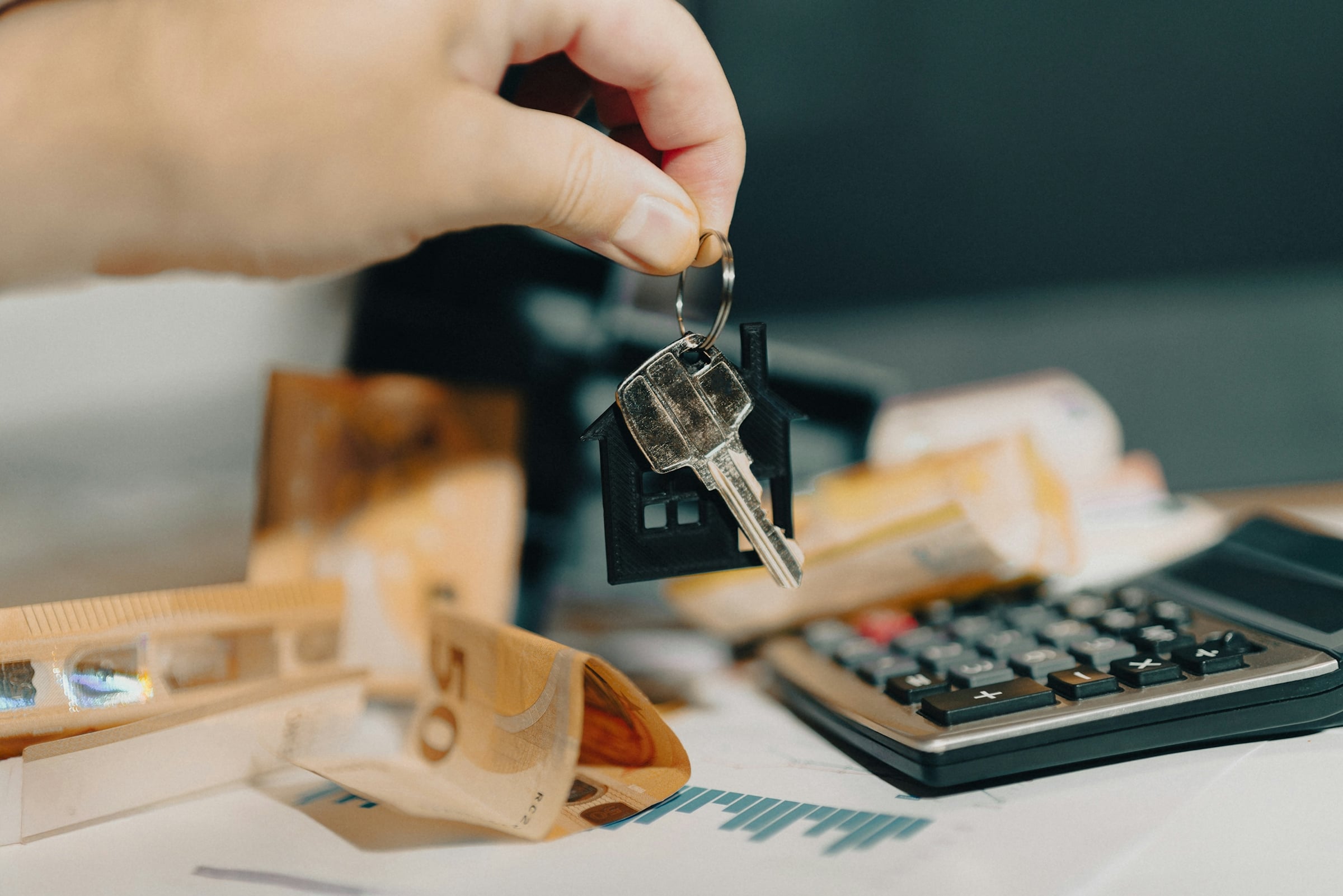 Person holding a house key, representing a new home buyer with a mortgage