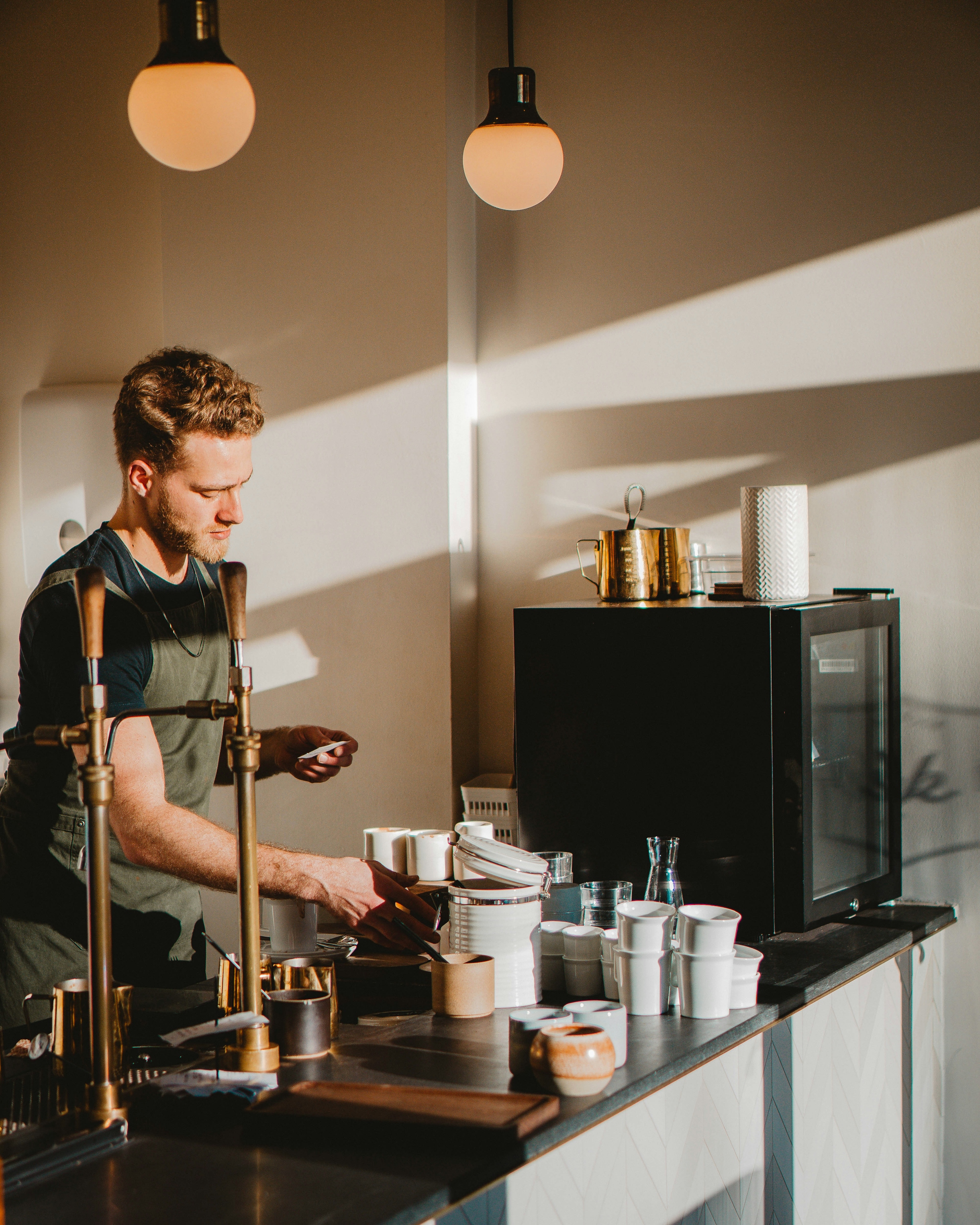 Barista in an apron preparing coffee at a counter