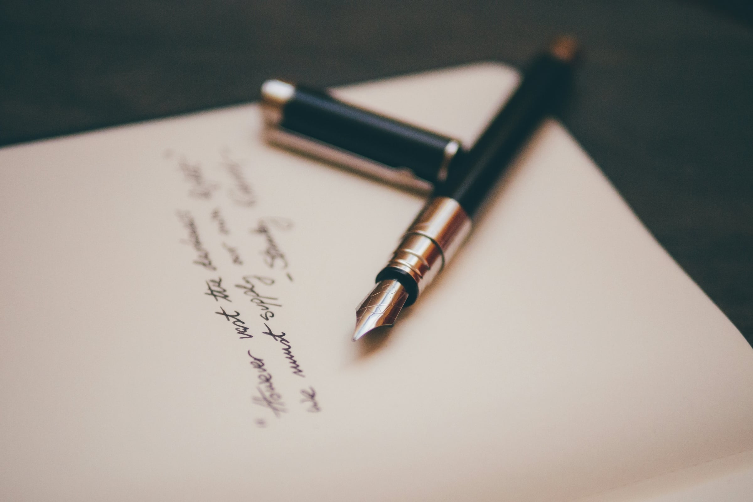 Fountain pen resting on a sheet of handwritten paper, representing signing a Virginia transfer on death deed