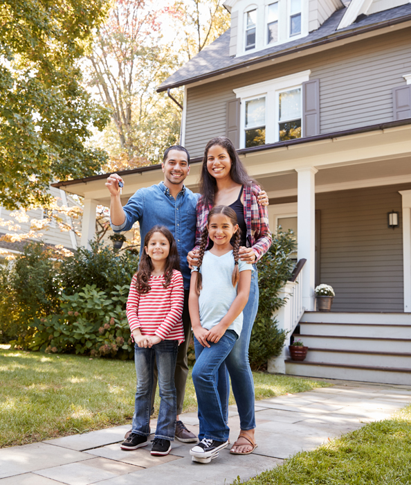 Portrait-Of-Family-Holding-Keys-To-New-Home-On-Moving-In-Day