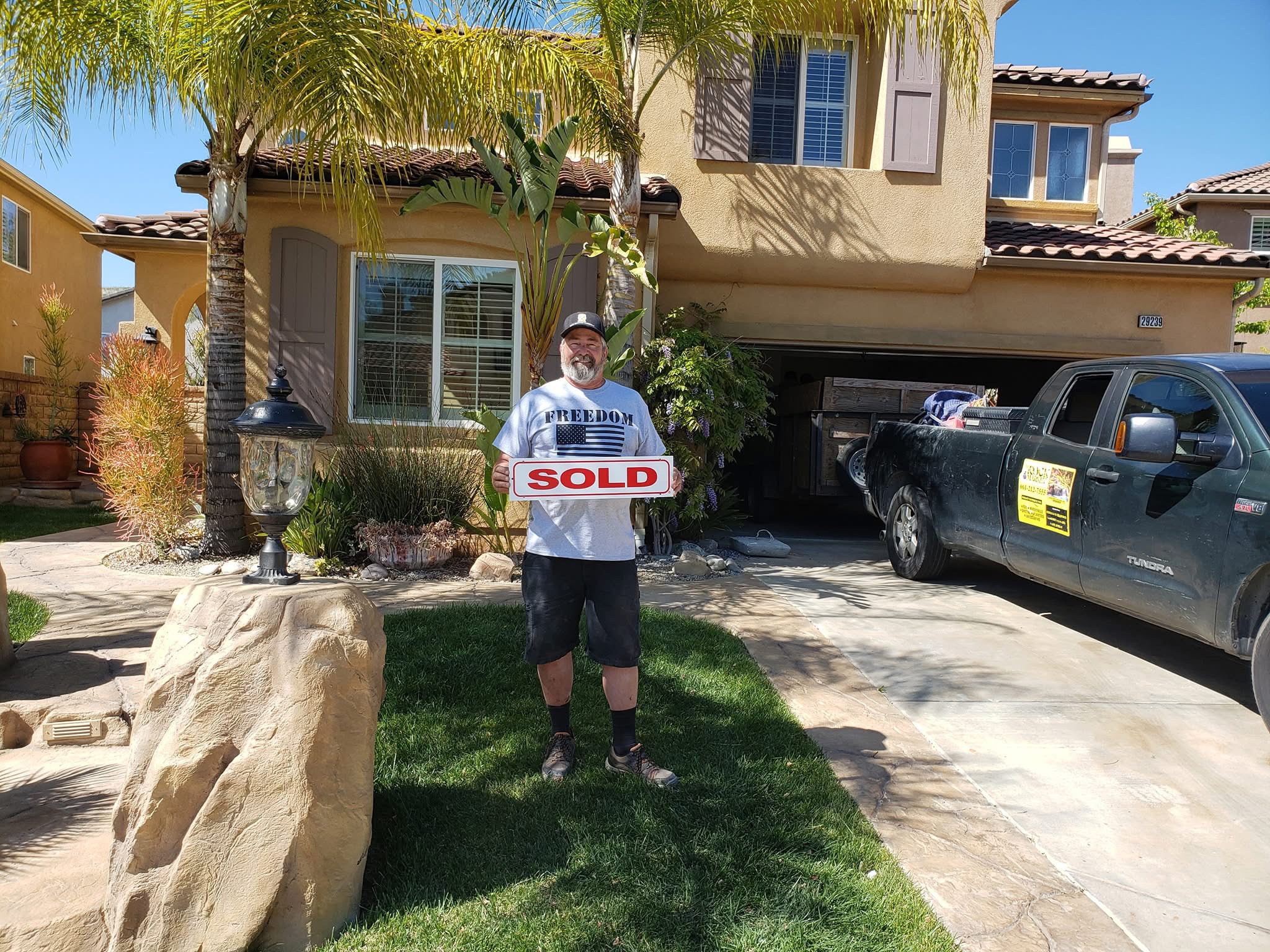 happy homeowner sold sign