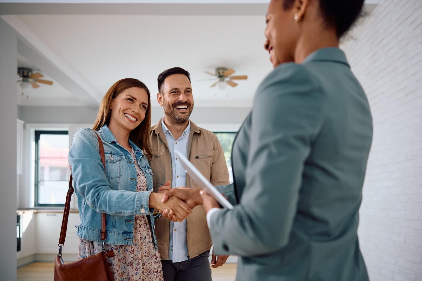 Happy woman shaking hands with real estate agent