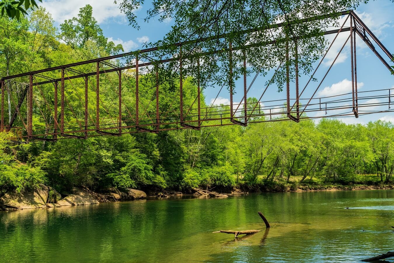 Old iron foot bridge stretching across the Chattahoochee river