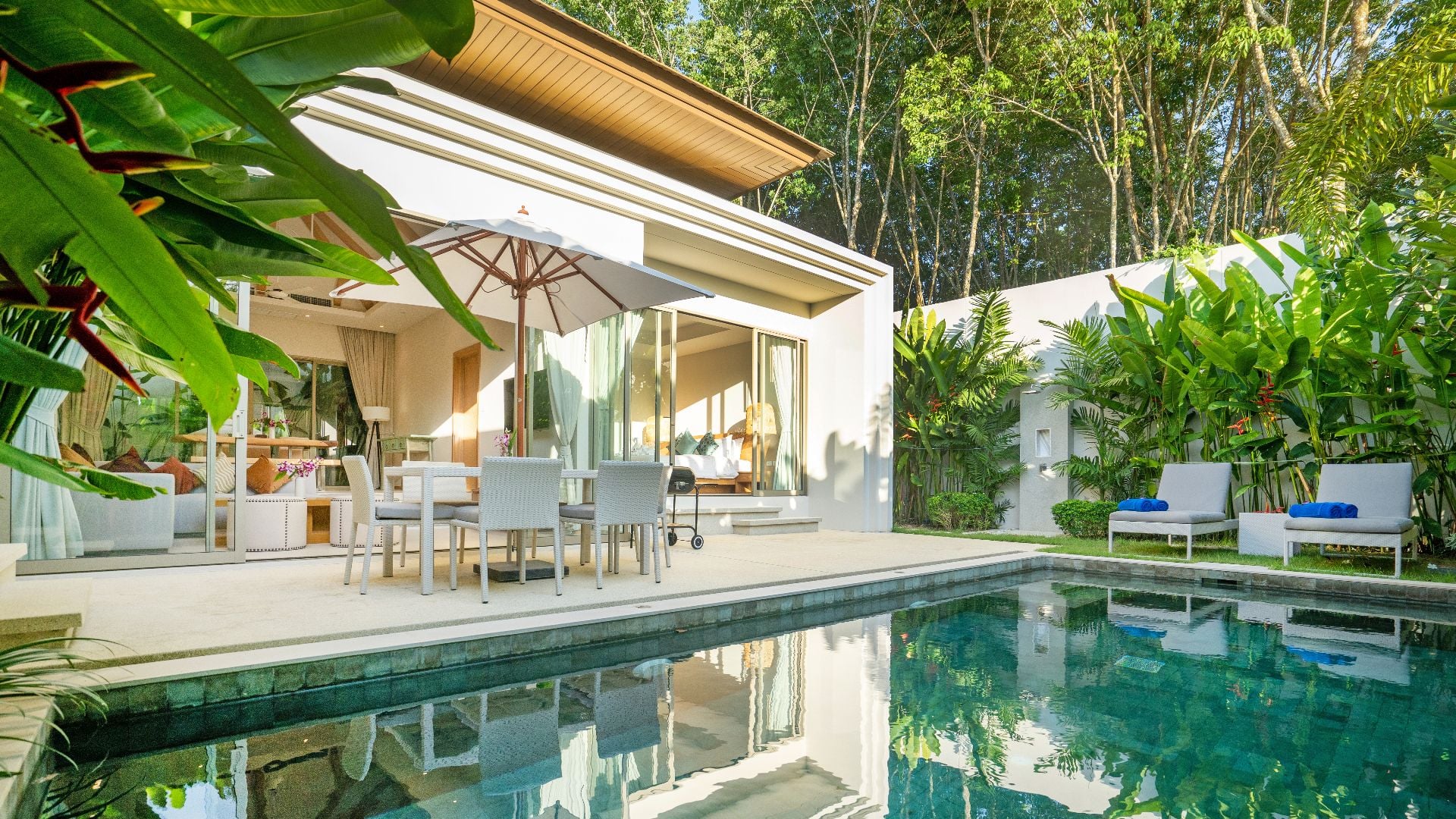 Interior and exterior design of luxury pool villa, house, home feature swimming pool, sunbed, blue beach towels and garden landscape(1)