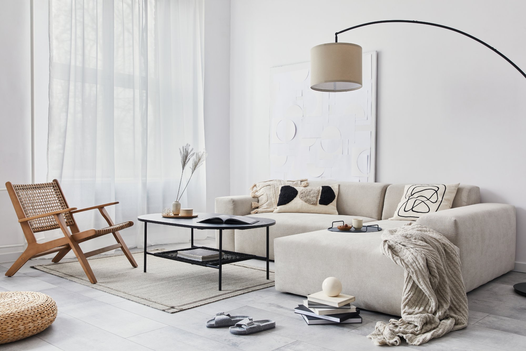 Domestic interior of living room with design modular sofa, black coffee table, lamp, armchair, decoration, art paintings and elegant personal accessories in modern home decor. Template.