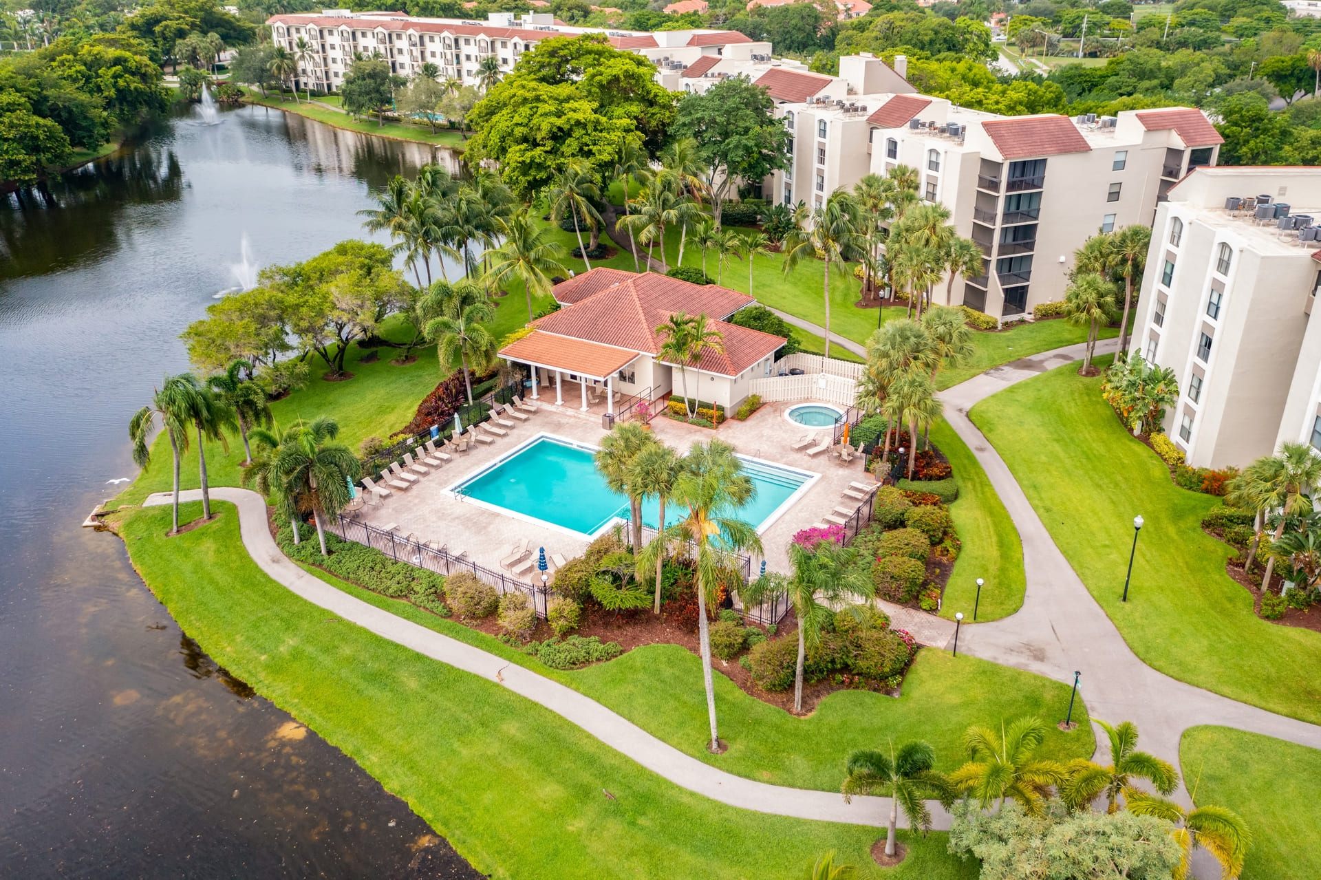 Aerial drone view to the suburbs in Delray Beach in Miami Florida, there is large tropical vegetation, houses with tiles