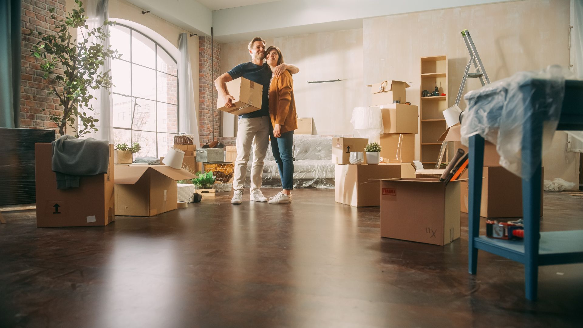 Family New Home Moving in Happy and Excited Young Couple Enter Newly Purchased Apartment. Beautiful Family Happily Embracing. Modern Home Ready for Decorations. Mortgage Loan, Investment Concept