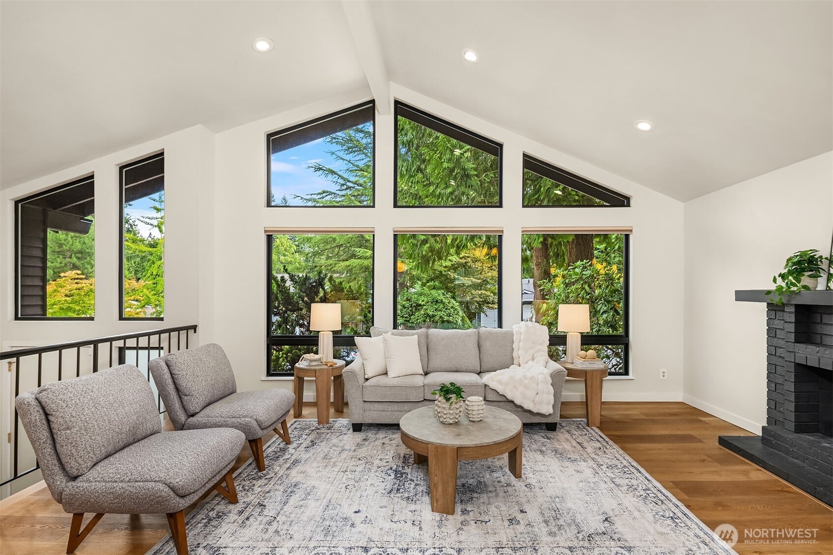 Bright Seattle-area home interior with vaulted ceilings, large windows, hardwood floors and a fireplace.