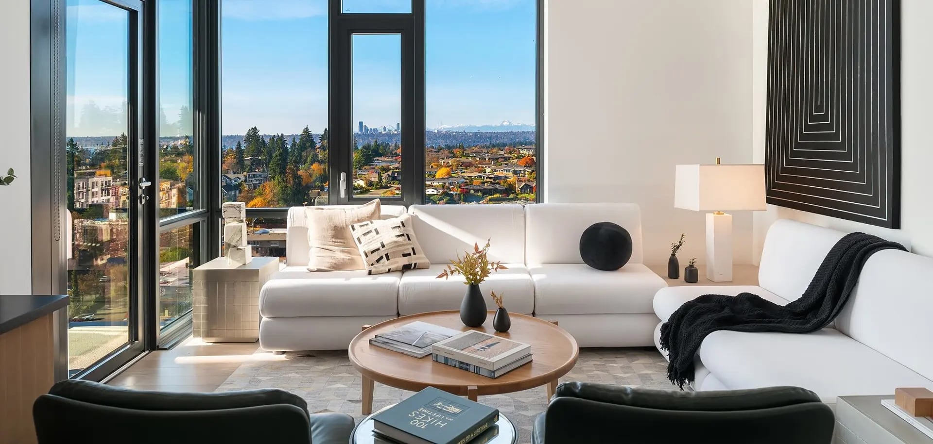 Downtown Bellevue condominium interior with floor-to-ceiling windows and views toward Seattle and the Olympic Mountains.
