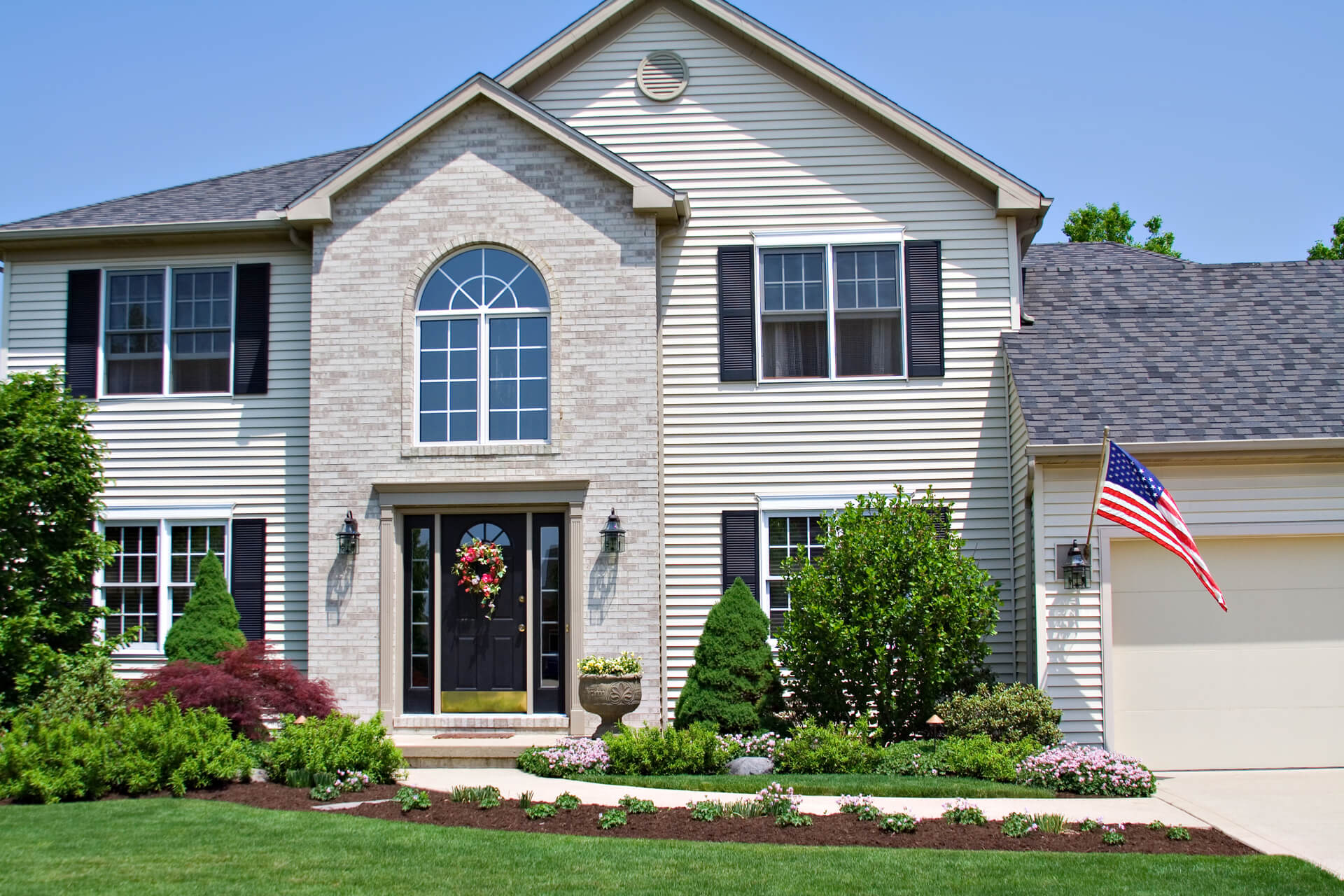 A beautiful neat suburban home in Ohio flying the American Flag.